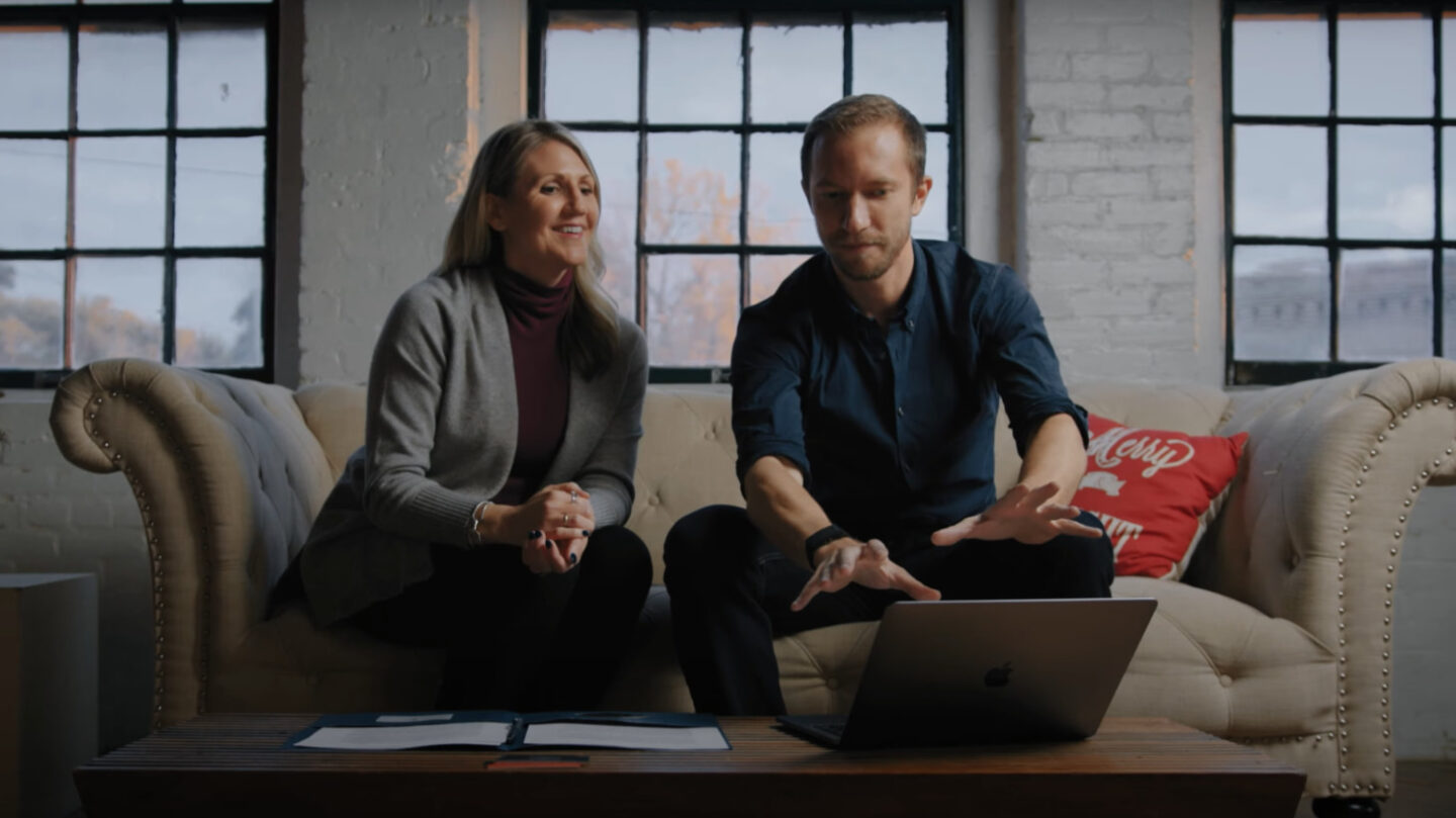 Two professionals discussing over laptop in modern office.